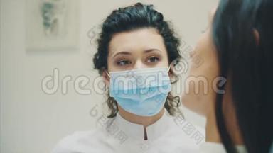 年轻的医生是一个穿着医用白色衣服和口罩的女人，做一个病人的回顾。 在考试期间